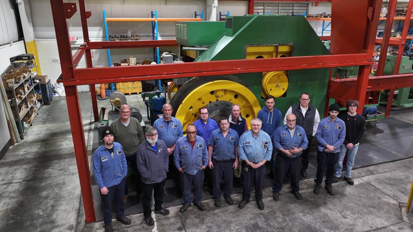 Aerial team portrait of a manufacturing crew in front of their machine